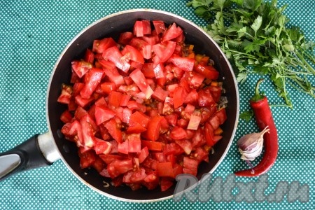 На помидорах сделать крестовые надрезы и обдать кипятком. Через минуту снять кожицу, нарезать мелкими кубиками и выложить в сковороду к луку, обжаренному с морковью.
