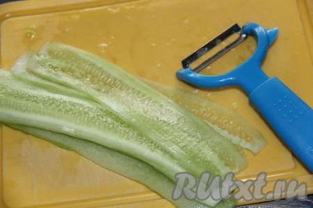 Огурец вымыть и нарезать на слайсы с помощью овощечистки.

