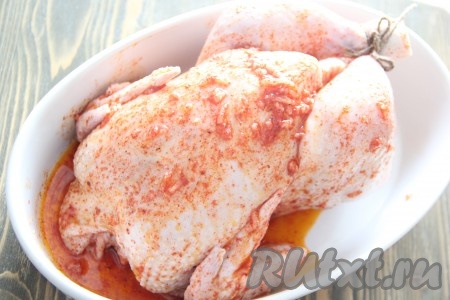 Цыплёнка достать из солёной воды и обсушить бумажным полотенцем. Хорошо втереть приготовленный маринад в цыплёнка снаружи и внутри (при желании, ножки цыпленка можно связать между собой). Переложить цыплёнка на противень или в форму для запекания и поставить  на 1 час в духовку, разогретую до 200 градусов. В процессе запекания периодически поливать цыплёнка выделившимся соком.