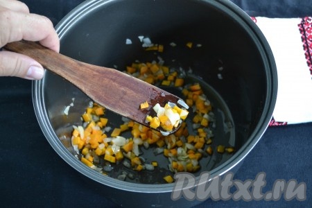 Очистить и нарезать мелкими кубиками морковь и лук. Мультиварку включить на функцию "Жарка", влить в чашу растительное масло и через минуту выложить лук с морковкой, перемешивая, обжарить овощи до мягкости (это займет 2-3 минуты).
