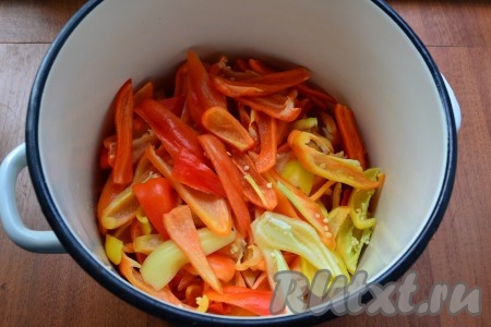 В большую кастрюлю выложить чеснок, далее - очищенный от семян и нарезанный дольками или крупными частями сладкий болгарский перец.
