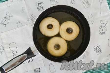 В сковороду влить растительное масло прогреть его 1-2 минуты, затем снизить огонь к минимуму  выложить часть пончиков.