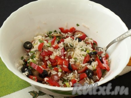 Овощной салат с рисом посолить, добавить в него 2-3 столовые ложки измельчённой зелени и заправку, хорошо перемешать.
