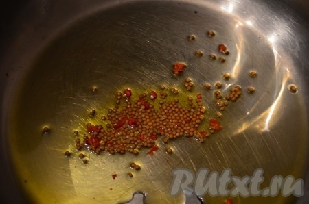 В кастрюле нагреть оливковое масло, добавить хлопья молотого чили и семена горчицы.
