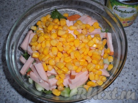 Добавить кукурузу в салат с ветчиной, огурцами и рукколой.
