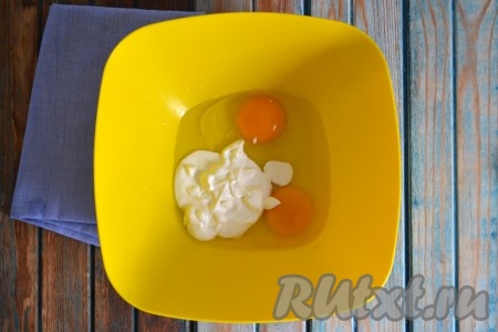 В глубокую миску вбить куриные яйца и добавить сметану. 