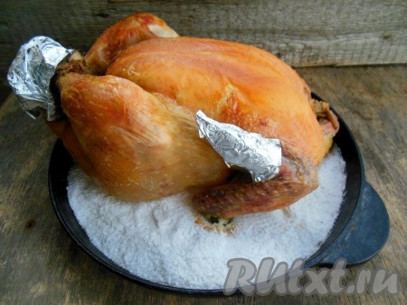 Заранее разогрейте духовку, поставьте в нее форму с курицей на соли. Запекайте при температуре 170-180 градусов около 1-1,5 часов (время приготовления зависит от массы курицы, на каждый килограмм мяса необходимо 35 минут запекания в духовке). Готовую целую курочку осторожно извлеките из формы, для этого используйте лопатку. Слейте образовавшийся сок.