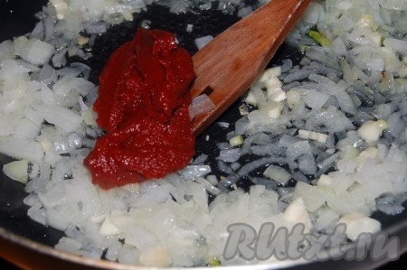 Обжарить лук и чеснок на растительном масле вместе с томатной пастой.