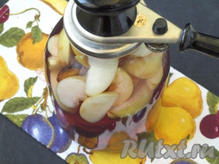 Кипящим сиропом залить банку со сливами, яблоками и лимонной кислотой до самого верха банки, накрыть крышкой и сразу же закатать компот.
