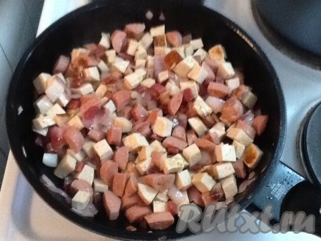 Нарезаем сосиски и колбасу небольшими кубиками и выкладываем на сковороду к обжаренному луку. Количество колбасных изделий используйте по вашему усмотрению. Обжариваем, помешивая, 5-7 минут.
