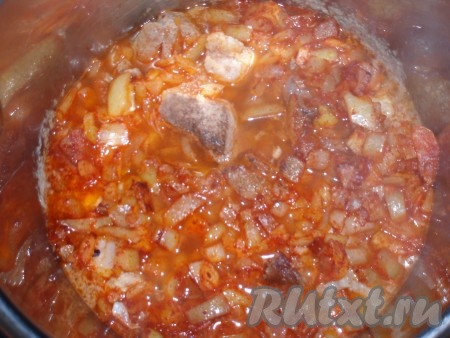 Добавить обжаренный лук в кастрюлю к мясу. Влить кипяток, чтобы вода чуть покрывала мясо, посолить, поперчить по вкусу.