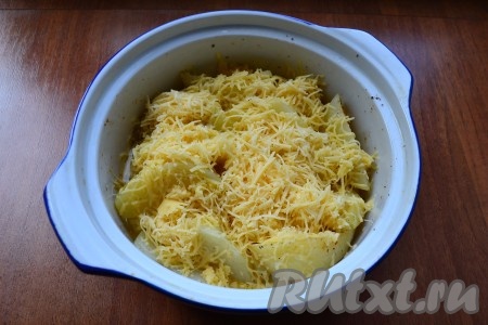 Картофель достать из духовки, залить яйцами и посыпать сверху натертым сыром.
