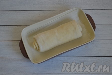 Выложить рулет с луковой начинкой в форму, застеленную пекарской бумагой. Накрыть салфеткой и оставить на 20 минут в теплом месте для подхода.
