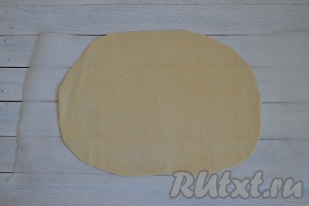 На столе, присыпанном мукой, раскатать тесто скалкой в тонкий пласт толщиной 3-4 мм.
