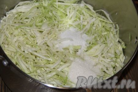 Выложить капусту в большую кастрюлю (объёмом 7-8 литров), добавить уксус, растительное масло, сахар и соль, хорошо перемешать.
