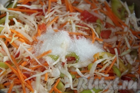 Выложить морковь в кастрюлю к овощам, хорошо перемешать, добавить соль, сахар, уксус и растительное масло, ещё раз тщательно перемешать. 
