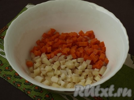 Очистить варёный картофель и морковь, нарезать кубиками и сложить в глубокий салатник.