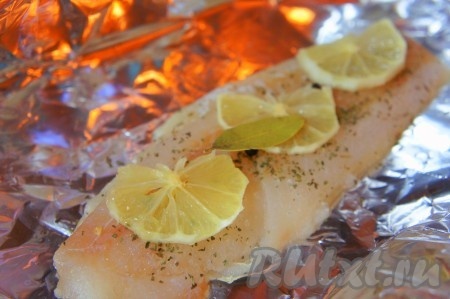 Духовку нагреть до 180-200 градусов. Рыбу выложить на фольгу, добавить соль, орегано, черный перец горошком, лавровый лист, дольки лимона. У лимона уберите предварительно кожуру, чтобы не было горчинки.
