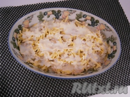 Сыр натереть на крупной терке и половиной сыра посыпать курицу сверху. Залить все половиной подготовленной кефирной заливки.
