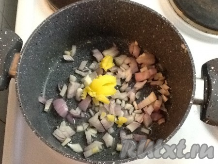 Взять кастрюлю, в которой будет вариться похлёбка, и разогреть сливочное масло (у меня - топлёное), затем выложить 1 очищенную и нарезанную луковицу.