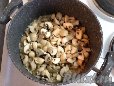 Дать луку немного обжариться, иногда помешивая. Вымыть шампиньоны и нарезать небольшими кусочками. Выложить грибы к луку, посолить и поперчить. Обжаривать, периодически помешивая, 5 минут.
