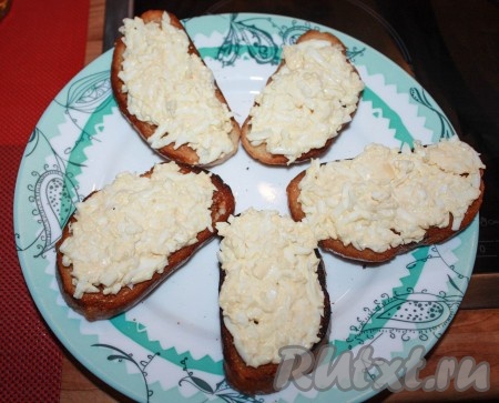 На каждый ломтик обжаренного хлеба выложить яично-сырную массу, распределить по всей поверхности.
