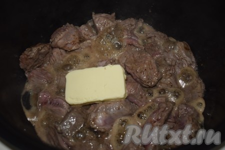 Затем закрыть крышку и продолжать жарить мясо еще минут 10. По истечении времени открыть крышку мультиварки и добавить к говядине кусочек сливочного масла.
