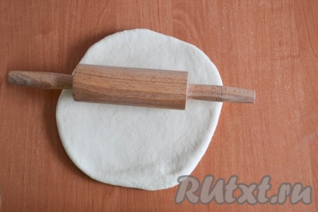 Затем выложить тесто на рабочую поверхность и начать раскатывать. Если тесто пристает к столу, можно притрусить стол мукой и капнуть 2-3 капли растительного масла.
