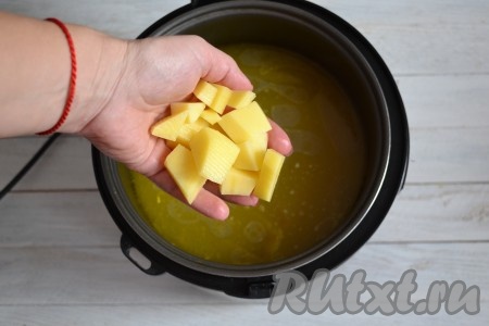 Очистить картофель и нарезать небольшими кубиками. Выложить его в бульон к перловке. Варить на функции "Суп" 20 минут под закрытой крышкой.
