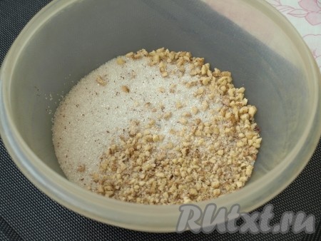 Очищенные грецкие орехи измельчить в крупную крошку. Половину сахара смешать с корицей, затем добавить к орехам, хорошо перемешать.
