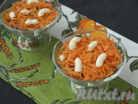 Сырую очищенную морковь натереть на тёрке и выложить поверх изюма. Нанести немного майонеза.

