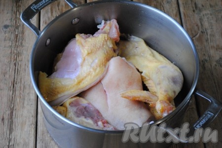 Курицу разделить на куски. Я готовила из домашнего петуха, но можно сварить и из покупной курицы, холодец в любом случае застынет и получится вкусным. Желирующее вещество содержится не в курином мясе, а в рульке. Куски курицы выложить в кастрюлю со свиной рулькой.
