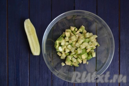 Очистить от кожуры огурец, нарезать небольшими кубиками и выложить к авокадо.
