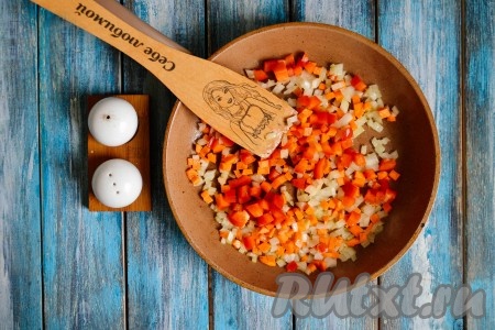 Лук с морковью очистить, нарезать мелкими кубиками и выложить в разогретую с растительным маслом сковороду. Вслед отправить сладкий перец, очищенный от плодоножки, семян и нарезанный мелкими кубиками. Обжарить перец, морковку и лук на среднем огне до мягкости (это займет не более 3 минут).

