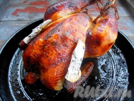 Запекайте курицу, замаринованную в меде и горчице, при температуре 170-180 градусов 1,5-2 часа, время от времени поливая верх птицы жиром, который выделился в процессе запекания. Если курица будет сверху быстро румяниться, просто прикройте ее слоем фольги. При накалывании готовой птицы из неё должен вытекать прозрачный сок, если вытекает сукровица - необходимо увеличить время приготовления.