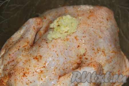 Тщательно втереть специи в куриное мясо внутри и снаружи. Затем добавить чеснок, пропущенный через пресс. Распределить чеснок поверх и внутри курицы. Оставить курицу мариноваться при комнатной температуре на 1-2 часа.
