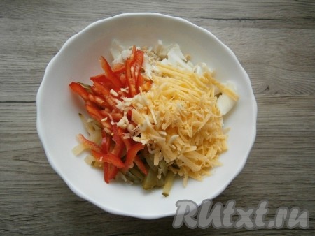 Сыр натереть на крупной терке, соломкой нарезать чеснок и болгарский перец, выложить в салат из копченой курицы, маринованных огурцов и яиц.