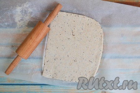 Выложить тесто между двумя листами пекарской бумаги. Раскатать скалкой в тонкий пласт толщиной 2-3 мм. Тесто раскатывается легко, подсыпать муку не надо.
