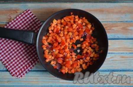 В сковороду влить растительное масло, выложить нарезанные морковку, сладкий перец и лук, обжарить на слабом огне 3-4 минуты, периодически помешивая.
