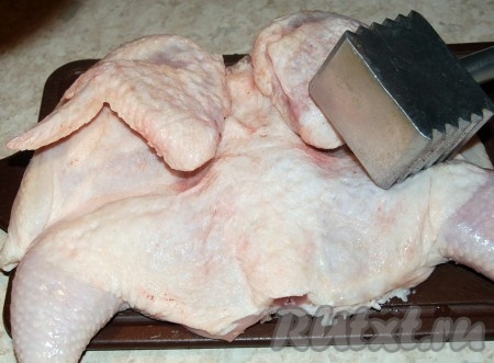 Слегка отбить тушку цыпленка молоточком, чтобы она приняла более плоскую форму.