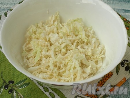 Тонко нарезать пекинскую капусту и сложить в салатник.