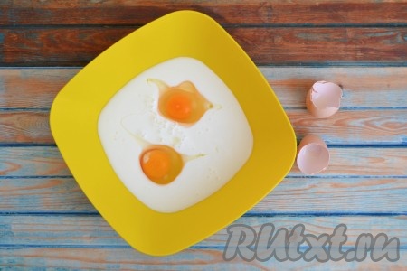 Кефир комнатной температуры влить в глубокую миску, добавить куриные яйца.