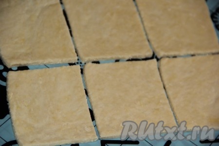 На присыпанном мукой силиконовом коврике (или на столе) раскатать тесто тонко в большой пласт. Нарезать тесто на квадраты или полоски любой величины.
