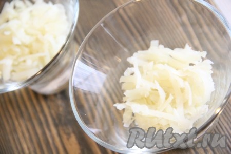 Выложить натёртый картофель на дно салатников или на плоскую тарелку. Немного посолить и смазать майонезом.
