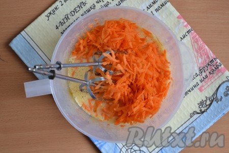 Очищенную морковь натереть на средней или крупной терке и выложить в яично-сахарную смесь.
