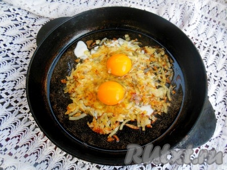 Разбейте яйца на сковороду так, чтобы желтки оказались в центре луковой массы. Желательно, чтобы желтки остались целыми.
