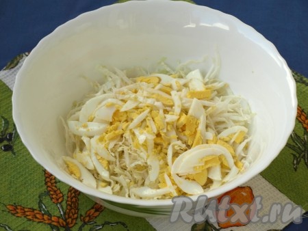 Тонко нарезать пекинскую капусту и сложить в миску. Очищенные вареные яйца, нарезав соломкой, выложить к капусте.
