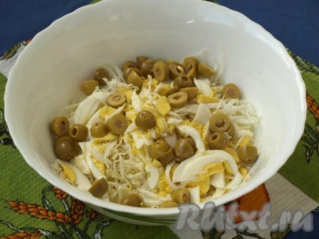 Разрезать оливки пополам и добавить в салат из яиц и пекинской капусты.
