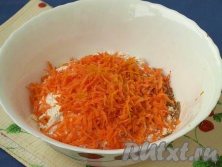 В миске смешать просеянную муку с содой, добавить корицу, молотый имбирь, мускатный орех, цедру апельсина и натёртую морковь.
