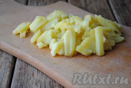 Картофель вымыть и отварить в кожуре в подсоленной воде до готовности (в течение 25-30 минут, готовая картошка будет легко прокалываться вилкой), затем остудить, очистить, нарезать на брусочки. 